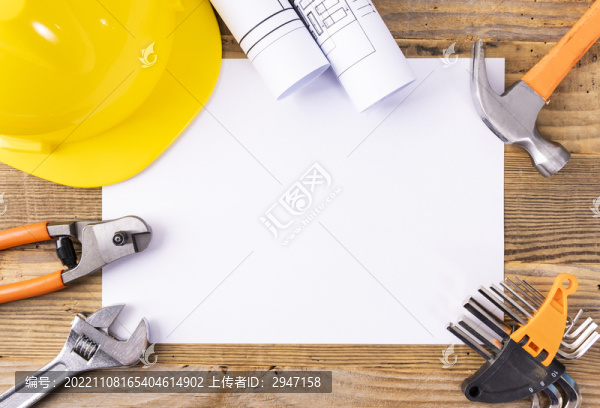木桌上放著的安全帽和圖紙工具