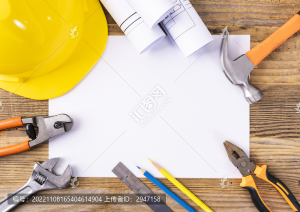 木桌上放著的安全帽和圖紙工具