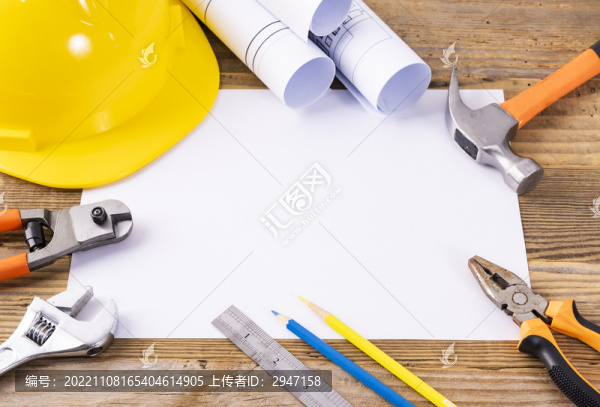 木桌上放著的安全帽和圖紙工具