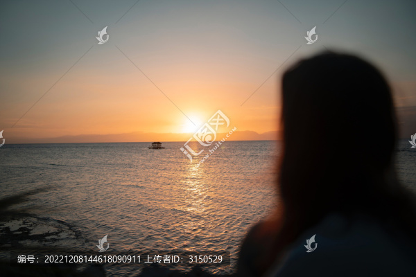 女人遙望大海與日落