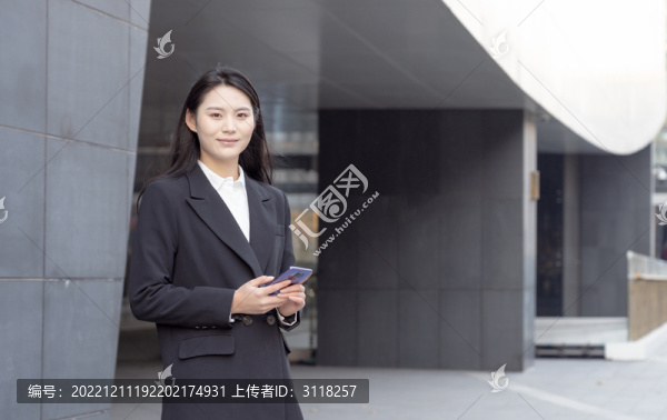 拿著手機(jī)的西裝女性