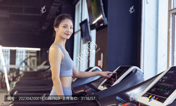 健身房使用跑步机的年轻女性