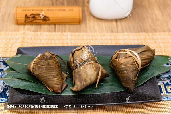 竹席中國(guó)風(fēng)背景前一盤(pán)煮熟的粽子