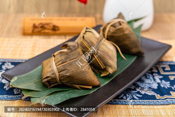 竹席中國(guó)風(fēng)背景前一盤(pán)煮熟的粽子