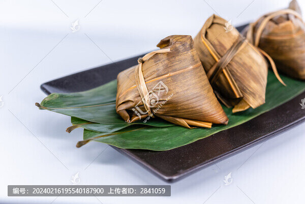 白色背景前一盤煮熟的粽子
