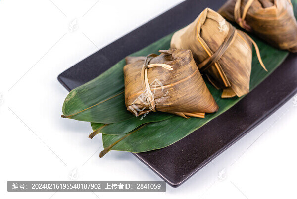 白色背景前一盤煮熟的粽子