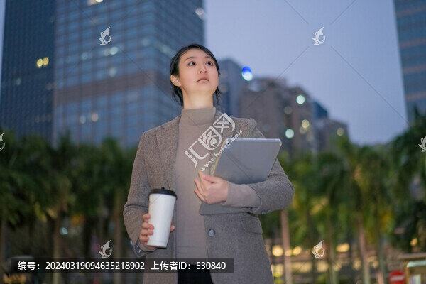職業(yè)女性拿著電腦行走在城市夜晚