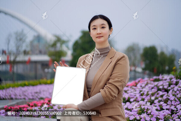 在公園里職業(yè)女性手持平板電腦