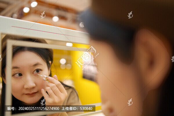在化妝鏡前體驗(yàn)睫毛膏的女性