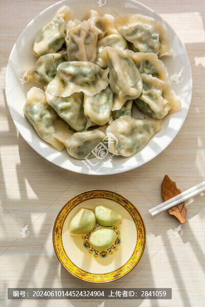 中國風(fēng)背景前的一碟臘八蒜和餃子