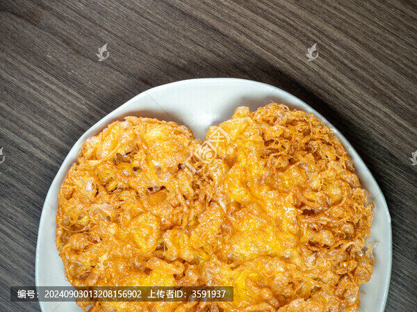 白色餐盤里金黃酥脆的炸雞蛋餅