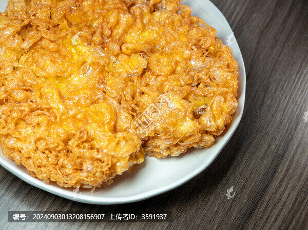白色餐盤里金黃酥脆的炸雞蛋餅