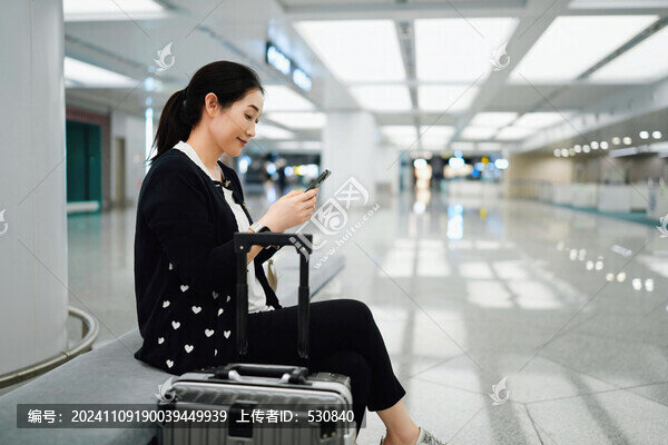 女人在機場休息室與智能手機互動