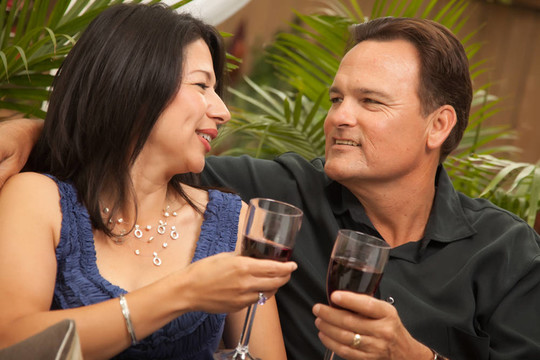 有吸引力的西班牙裔和白人夫妇饮用葡萄酒