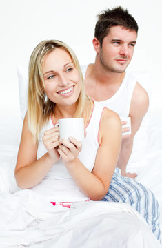 一对夫妇在床上喝一杯茶