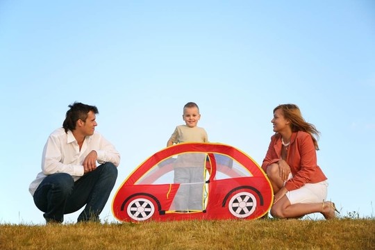 草地上的家庭和玩具帐篷