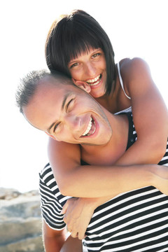 微笑的年轻夫妇在海滩上玩得很开心