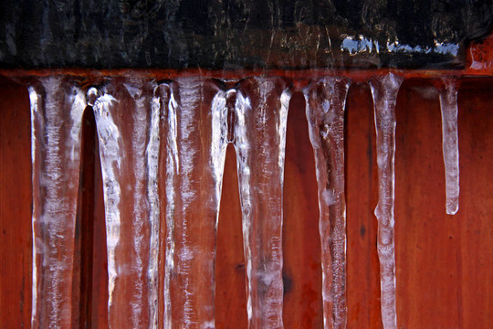 冬季冰柱在一个木制的花园的门