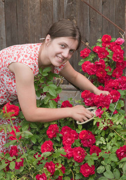 年轻的姑娘微笑着花店在花园里工作