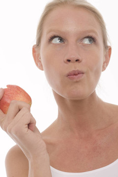 年轻美丽的白人女子吃，拿在手里的苹果