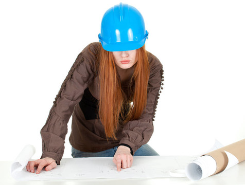 女建筑师在蓝色头盔阅读蓝图