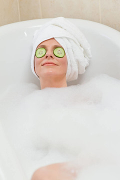 放松的女人用毛巾在头上洗澡