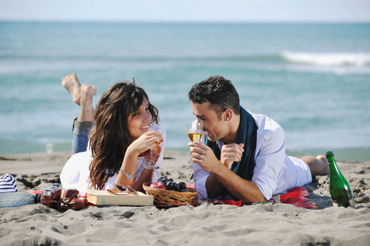 年轻夫妇在海滩上野餐