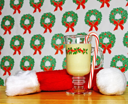 一杯圣诞蛋酒在桌上用花环的背景和一个圣诞帽使用选择性聚焦和浅景深