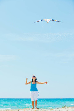 海滩上玩彩色风筝的女人