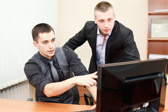 特写镜头的年轻人指着屏幕显示一些他的同事