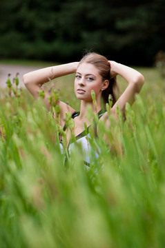 美丽的少女在田野的草丛中