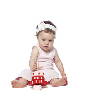 婴儿在粉红色的衣服玩红色玩具