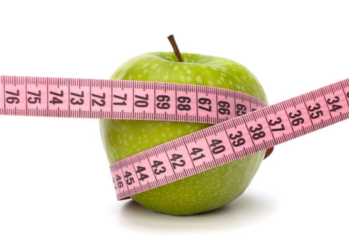 带带测量的苹果。健康生活方式概念。