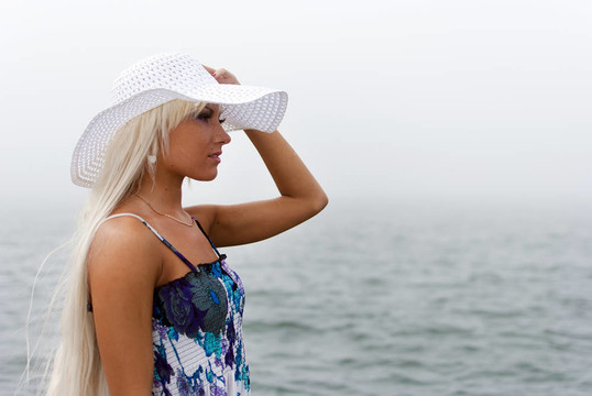 戴帽子的女孩站在雾海中