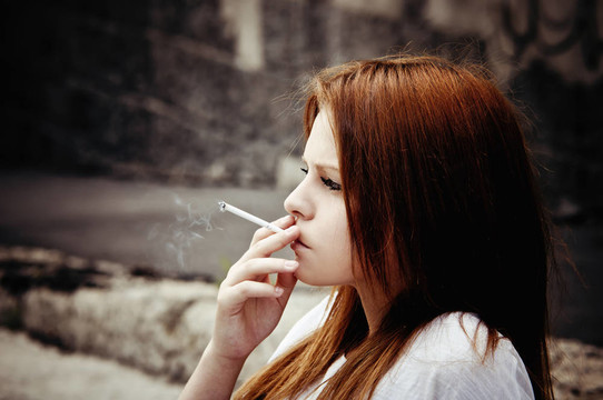 吸烟美丽的年轻女孩
