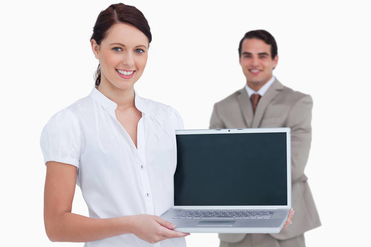 售货员微笑着将笔记本电脑的屏幕和同事在她身后在白色背景