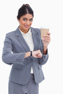面带微笑的女企业家用纸杯在白色背景下检查时间