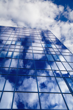 摩天大楼的窗户在一片多云的天空中反射