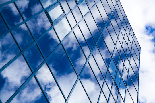 摩天大楼的窗户在一片多云的天空中反射