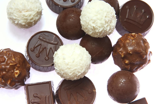 美味可口的巧克力糖果和坚果和椰子是稀疏的白色背景上