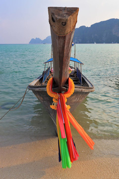 橙色的泰国旅游船停泊在海滩上的