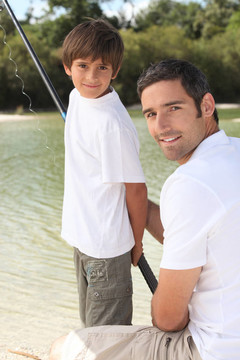 父亲和儿子在湖边钓鱼