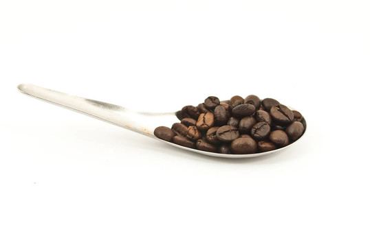 汤匙上的咖啡豆。