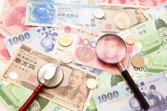 亚洲货币；随着亚洲货币背景放大镜和听诊器（包括韩元；台湾元；中国货币元；香港美元；日元）；金融概念
