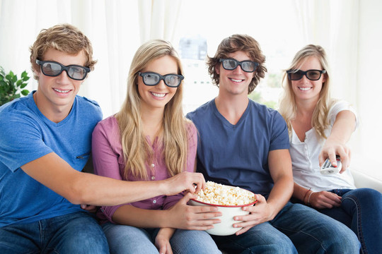 朋友们微笑着吃爆米花，看3D电影