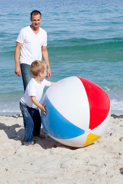 忧郁的父亲和他的儿子在玩沙滩球