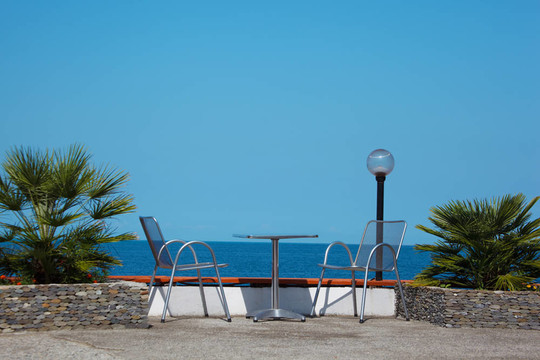 海岸休息。海滩晴朗夏日的桌子和椅子。