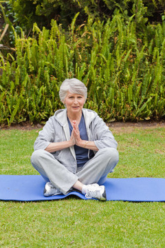 退休女子在花园里练瑜伽