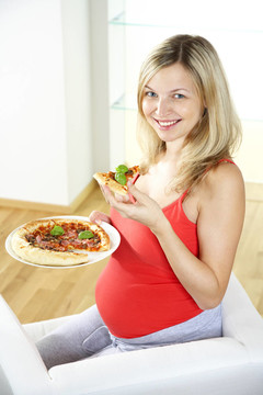年轻孕妇吃比萨饼
