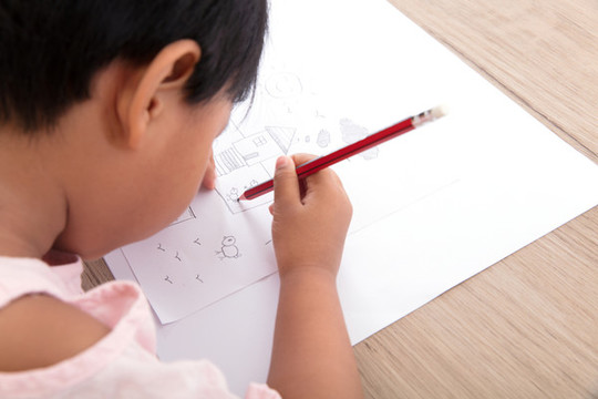 幼儿园的小女孩在认真的画简笔画